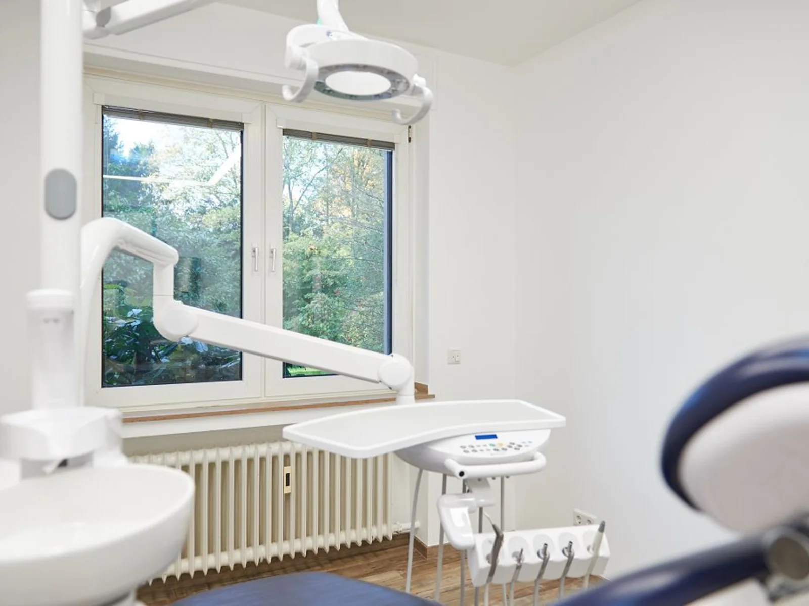 Helles Behandlungszimmer mit Behandlungsstuhl und Fenster in der Praxis Uerdinger Straße